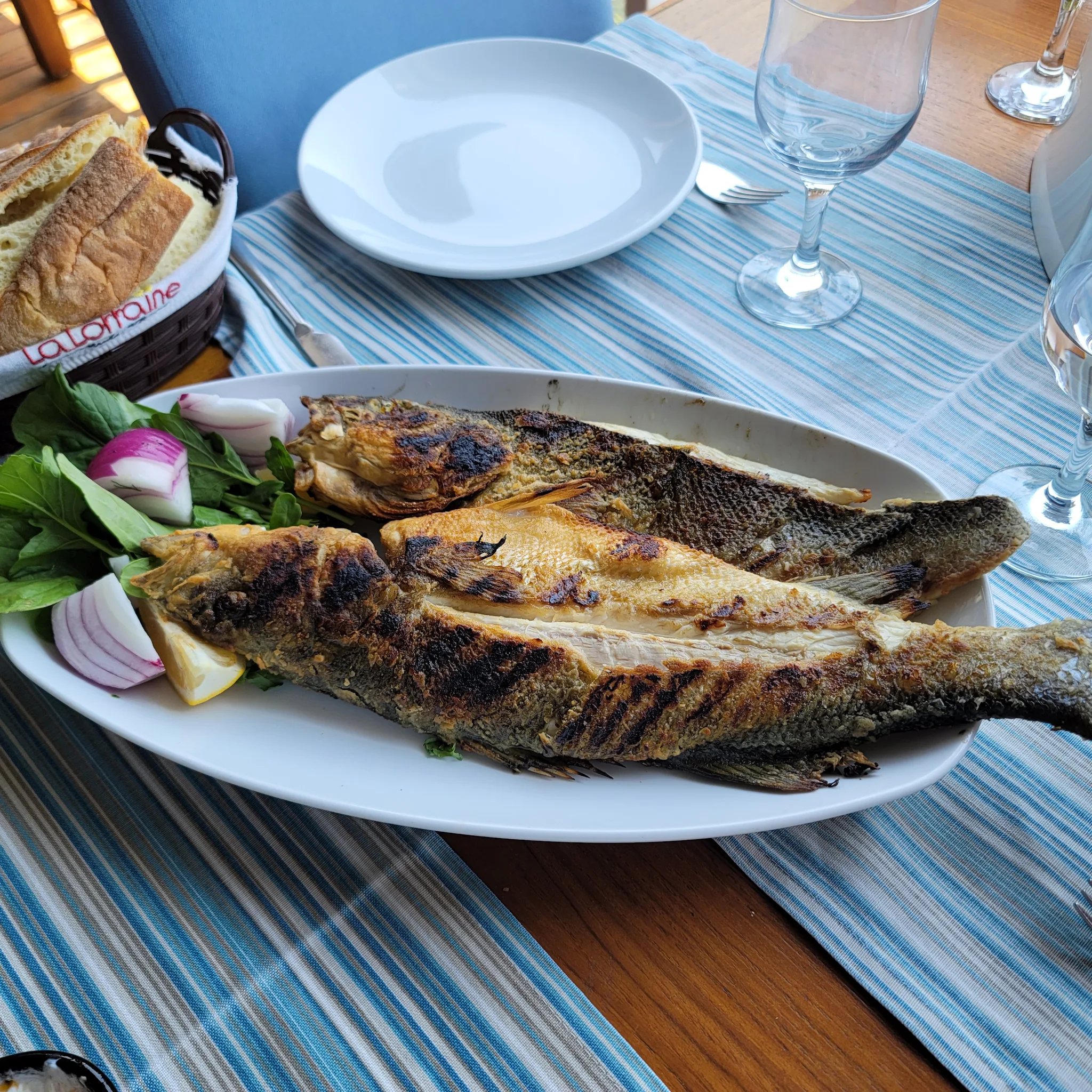Grilled fish and accompaniments served at Olta Restaurant