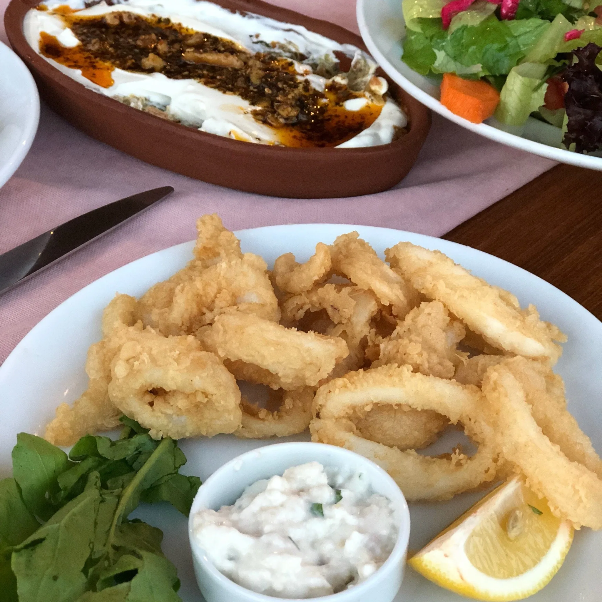 Olta Restaurant’ta limon, roka ve sosla servis edilen kızarmış kalamar